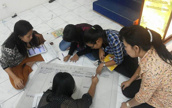 students gathered on floor looking at papers