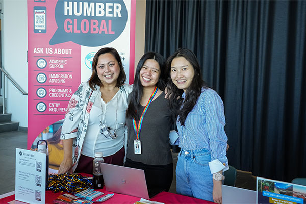 a group of women standing next to the Humber Global Booth