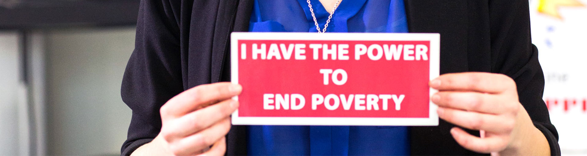 Person holding a sign thats saysI have the power to end poverty